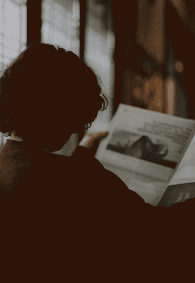 A person reading a printed newspaper